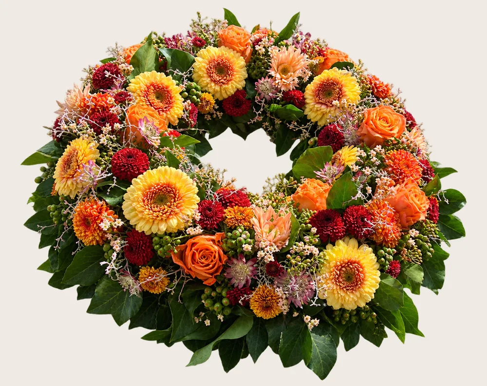 Kranz mit Gerbera, Rosen und Beeren in Gelb und Orange