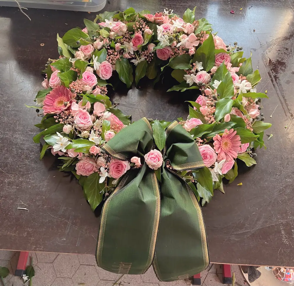 Kranz mit rosa Rosen und grüner Schleife