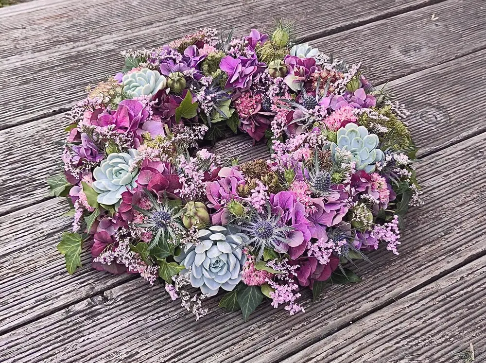 Kranz mit Sukkulenten und Blumen in Violett
