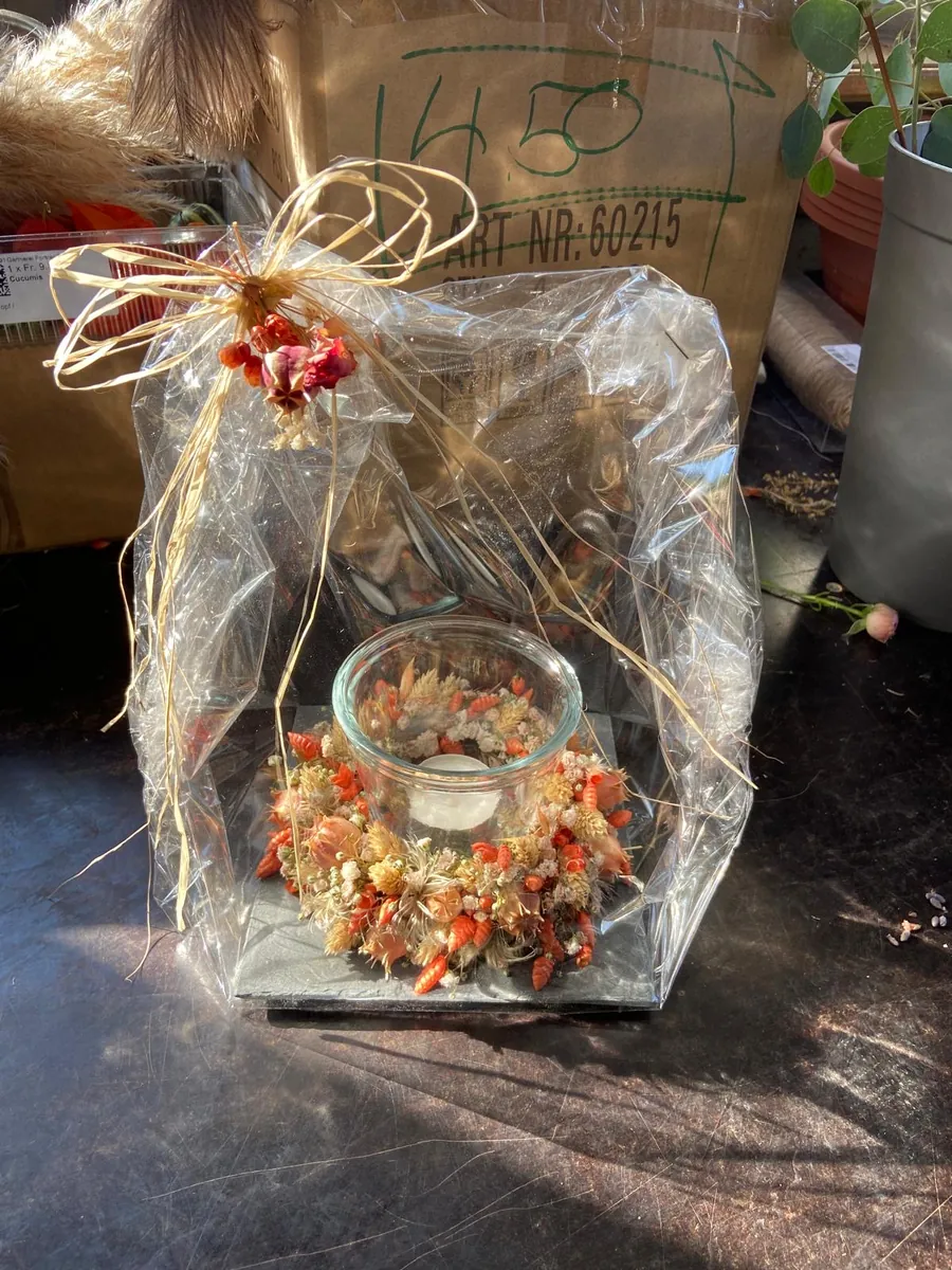 Windlicht mit Trockenblumenkranz, als Geschenk verpackt mit Bastschleife